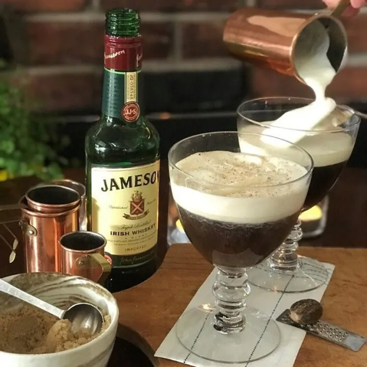 Προσθετοντας κρεμα για ιρλανδικο καφε σε γυαλινο ποτηρι